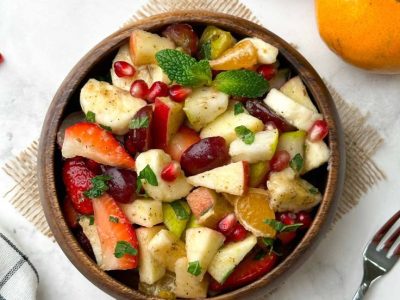 fruit chaat served in a wooden bowl with fruits in…